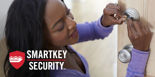 Black women wearing purple shit installing a Kwikset Smartkey Security Deadbolt into a door at eye level